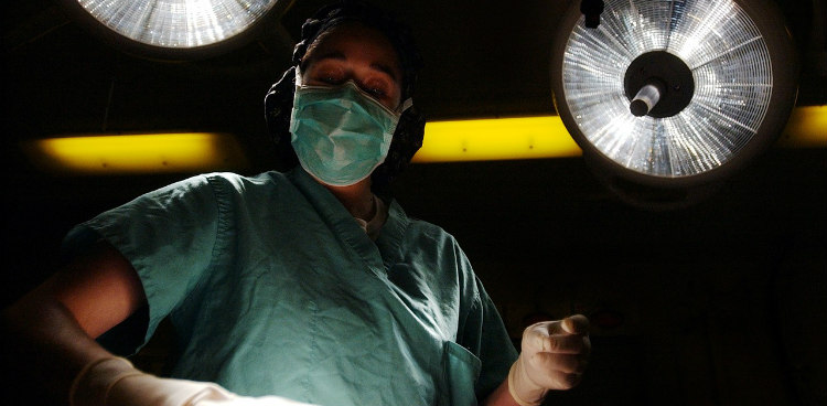 Doctor Standing Over Patient