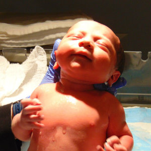 nurse holding newborn operating room
