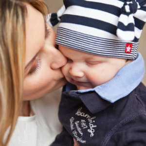mom kissing baby on cheek
